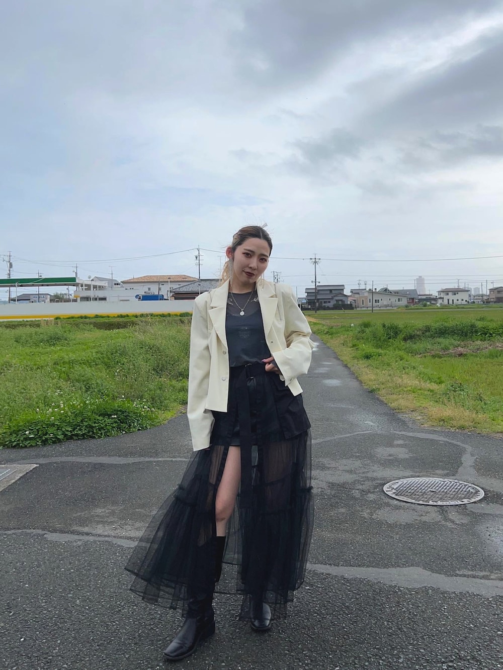 ホワイト系のテーラードジャケット、ブラック系のスカート、ブラック系のスカートを着用したレディースの春コーディネートの2枚目の写真