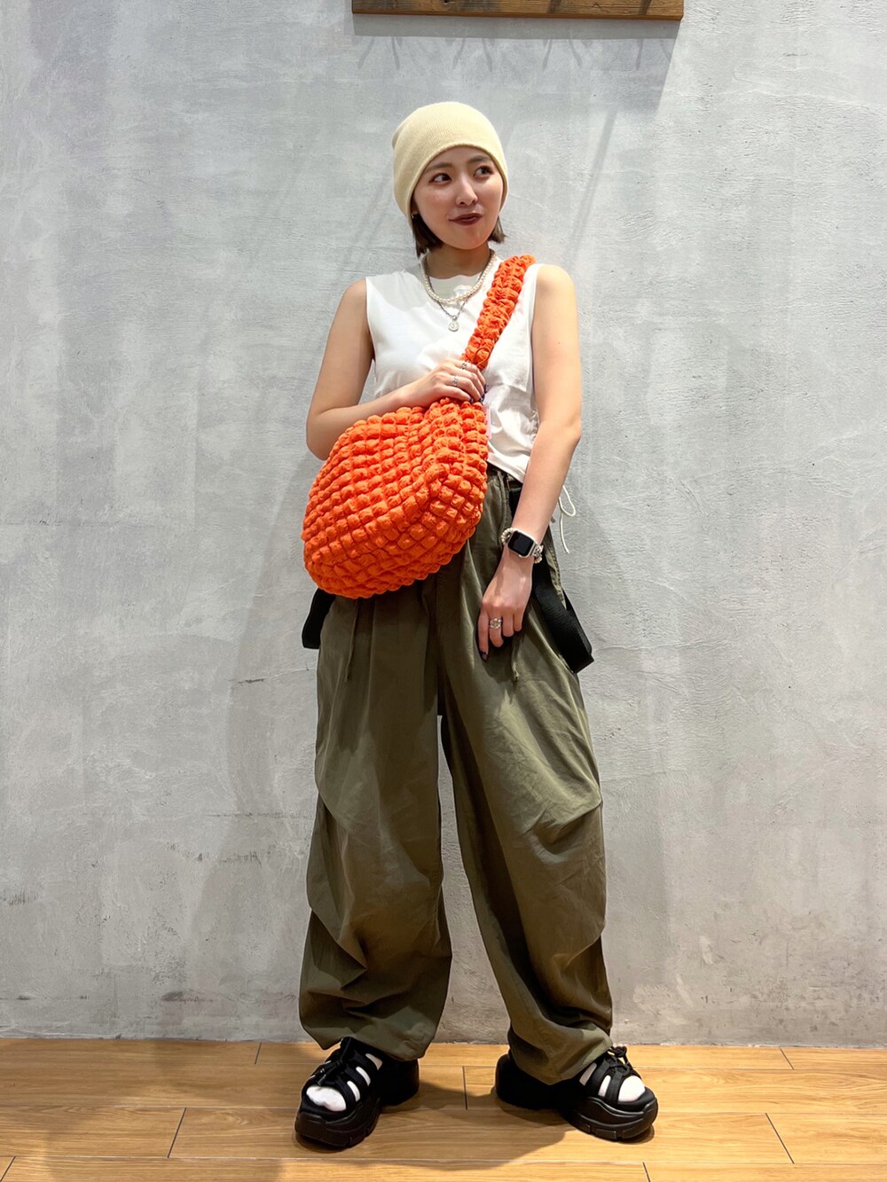 グリーン系のその他パンツ、ホワイト系のTシャツ/カットソー、オレンジ系のショルダーバッグを着用したレディースの夏コーディネートの2枚目の写真