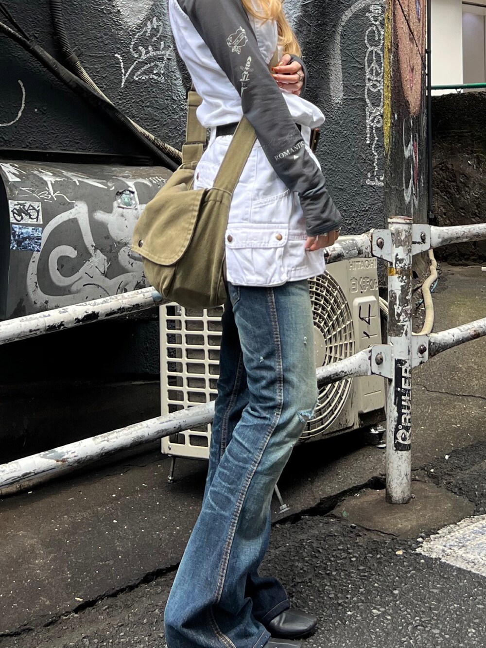 グレー系のTシャツ/カットソー、ホワイト系のジャンパースカート、ブルー系のデニムパンツを着用したレディースの春コーディネートの4枚目の写真