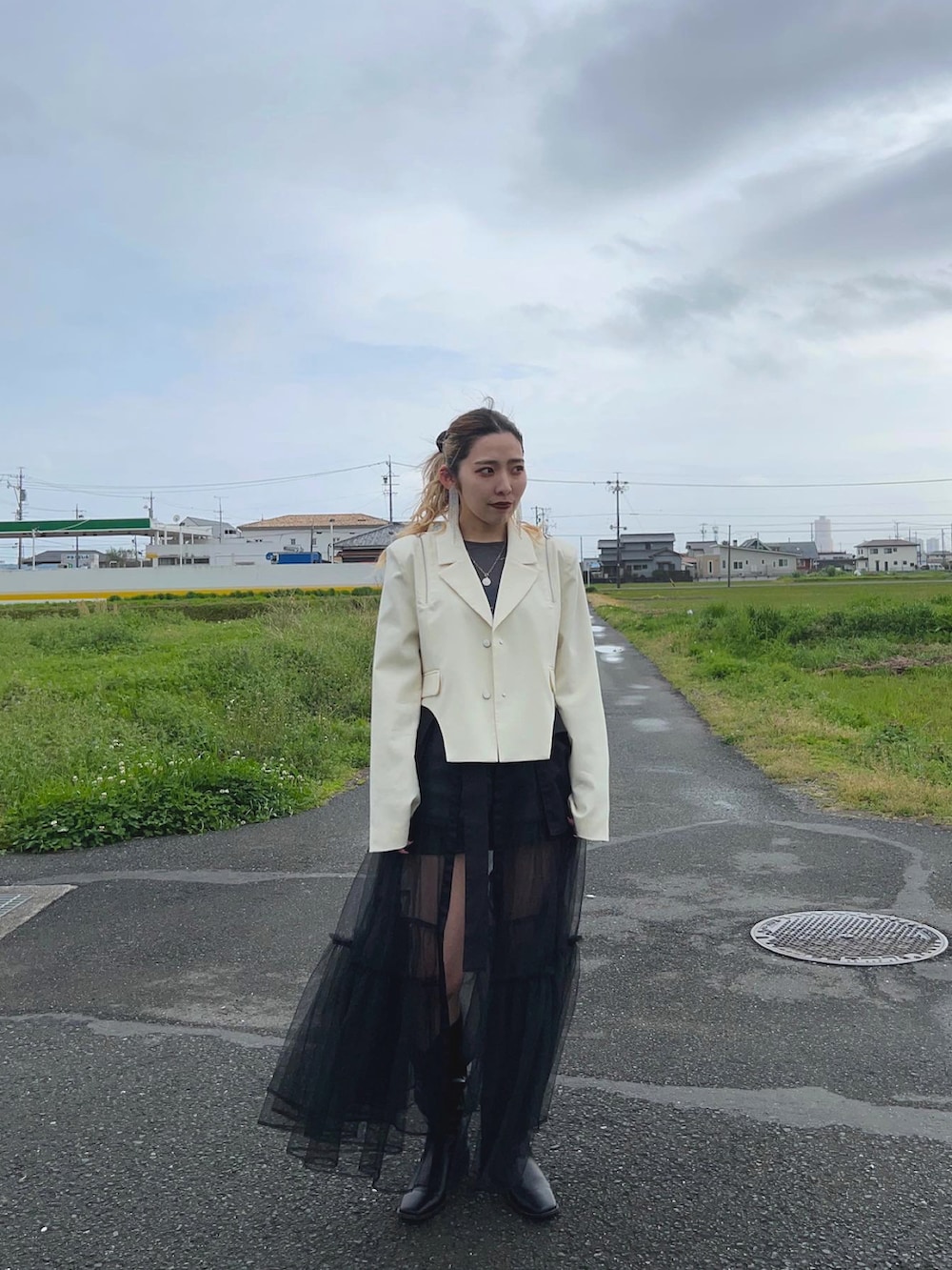 ホワイト系のテーラードジャケット、ブラック系のスカート、ブラック系のスカートを着用したレディースの春コーディネートの3枚目の写真