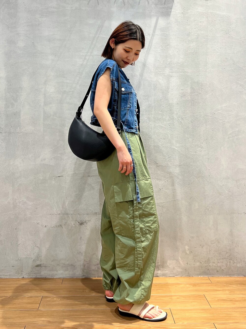 グリーン系のカーゴパンツ、ホワイト系のサンダル、ブルー系のその他アウターを着用したレディースの夏コーディネートの3枚目の写真