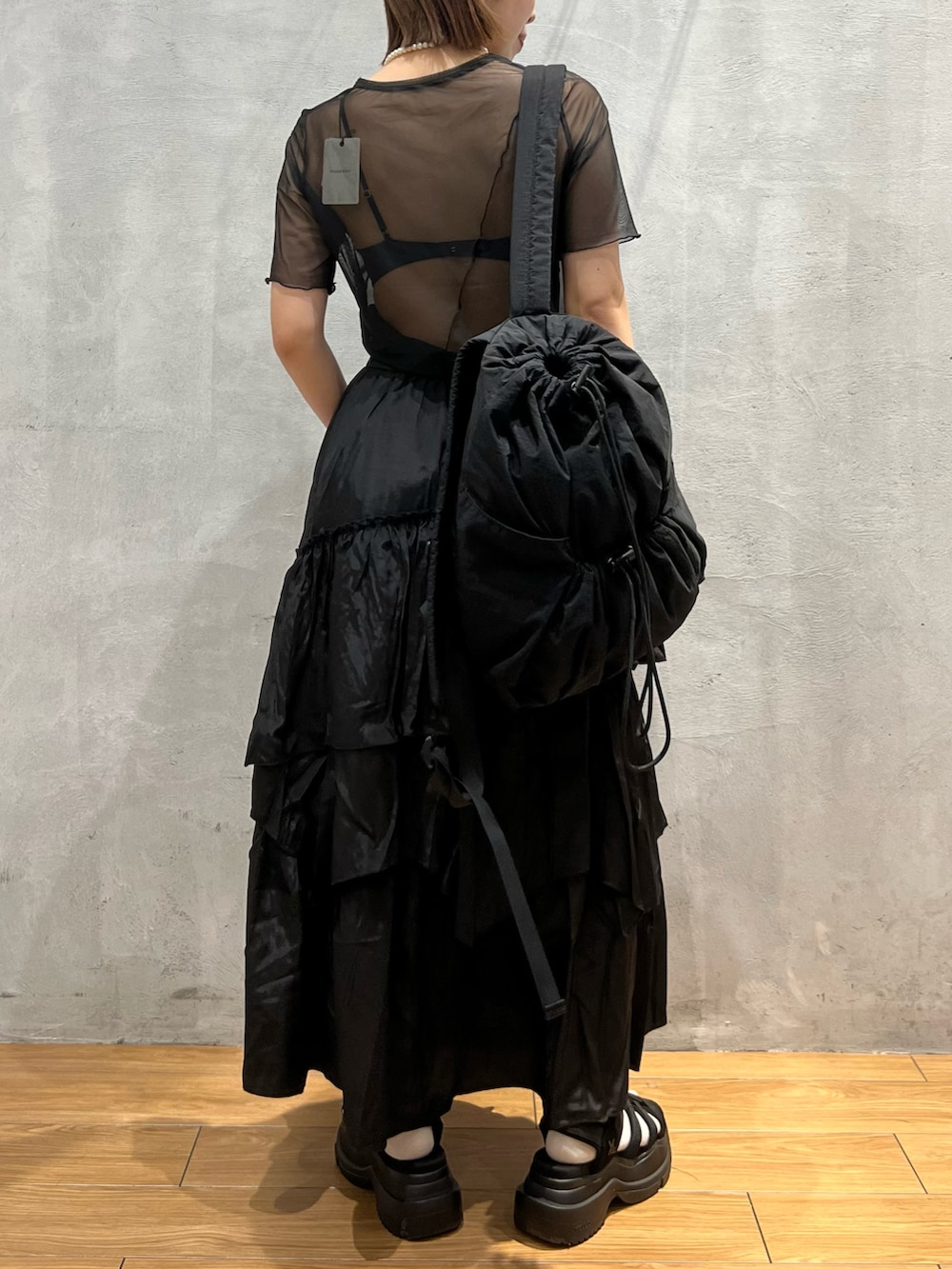 ブラック系のスカート、ブラック系のTシャツ/カットソー、ブラック系のバックパック/リュックを着用したレディースの夏コーディネートの4枚目の写真