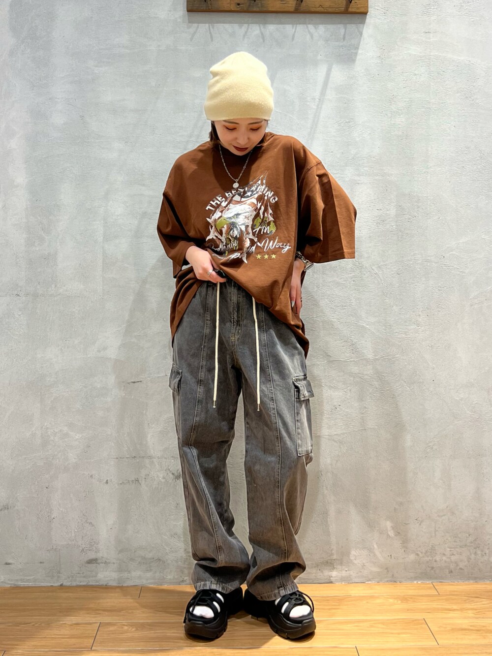 ブラウン系のTシャツ/カットソー、ブラック系のデニムパンツ、ブラック系のサンダルを着用したレディースの夏コーディネートの2枚目の写真