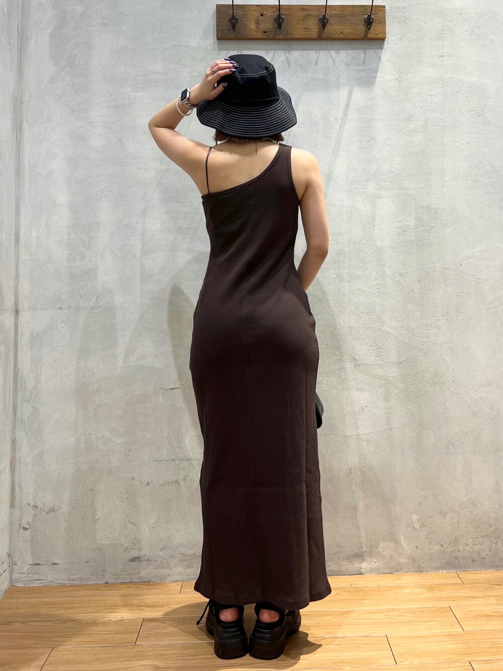 ブラウン系のワンピース、ブラック系のハンドバッグ、ブラック系のハットを着用したレディースの夏コーディネートの4枚目の写真