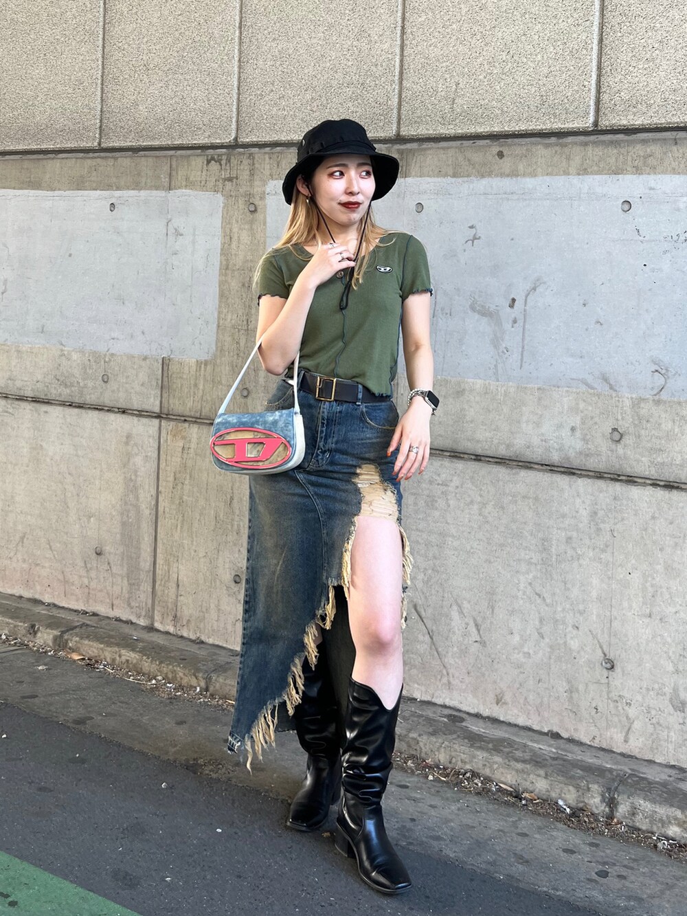 グリーン系のTシャツ/カットソー、ブルー系のデニムスカート、ブルー系のショルダーバッグを着用したレディースの春コーディネートの2枚目の写真