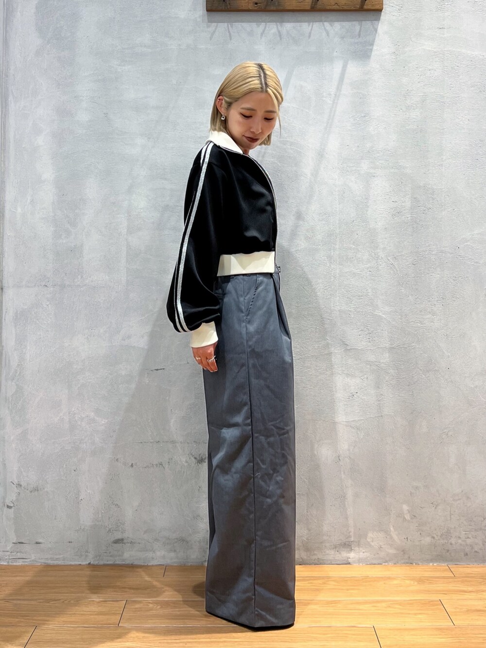 グレー系のスラックス、ブラック系のジャケット/アウター、ホワイト系のタンクトップを着用したレディースの秋コーディネートの3枚目の写真