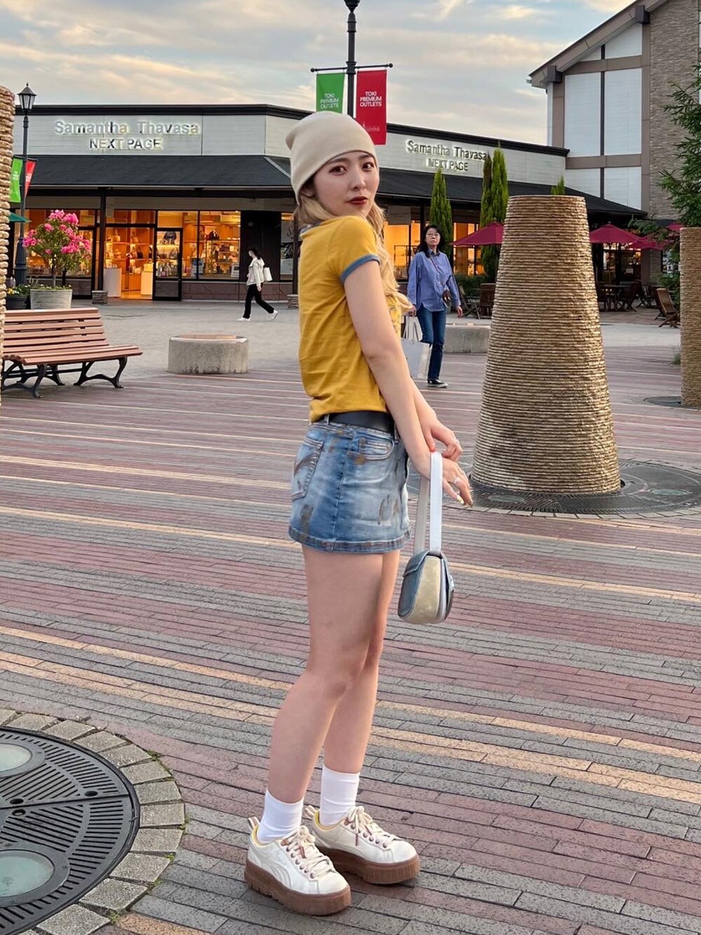 イエロー系のTシャツ/カットソー、ブルー系のデニムスカート、ブルー系のショルダーバッグを着用したレディースの春コーディネートの2枚目の写真