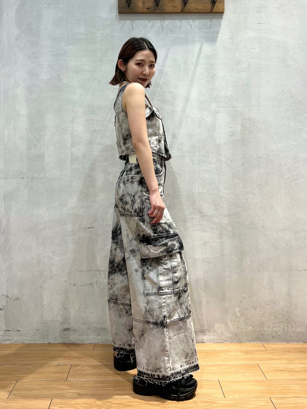 ブラック系のベスト、ブラック系のデニムパンツ、ブラック系のハンドバッグを着用したレディースの夏コーディネートの3枚目の写真