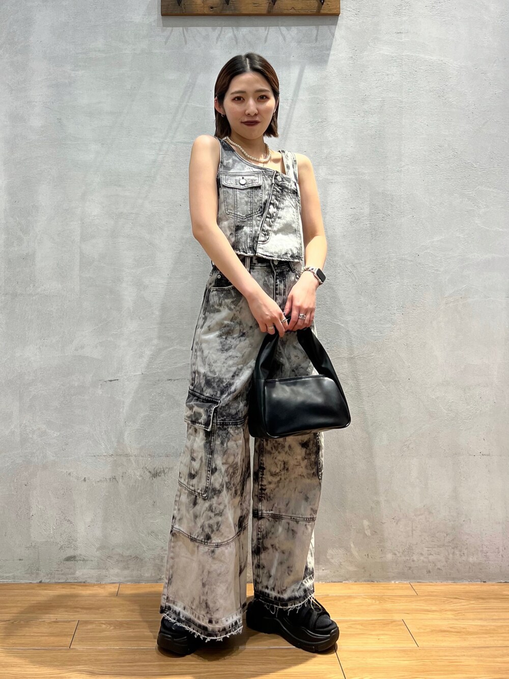 ブラック系のベスト、ブラック系のデニムパンツ、ブラック系のハンドバッグを着用したレディースの夏コーディネートの2枚目の写真