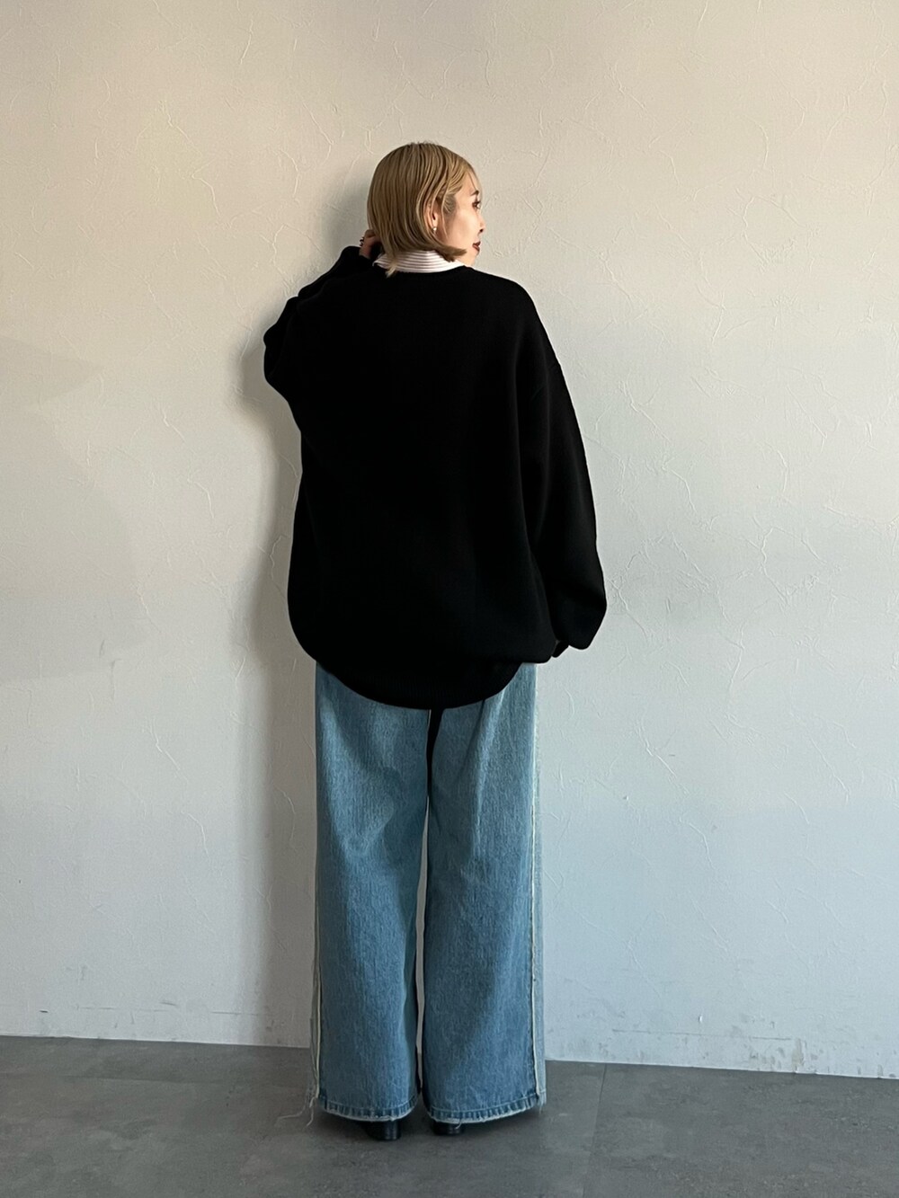 ブラック系のニット/セーター、ブルー系のデニムパンツ、ピンク系のシャツ/ブラウスを着用したレディースの秋コーディネートの5枚目の写真