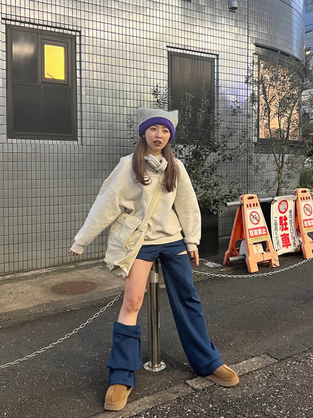 グレー系のスウェット、ブルー系のスウェットパンツ、ブラウン系のブーツを着用したレディースの春コーディネートの2枚目の写真
