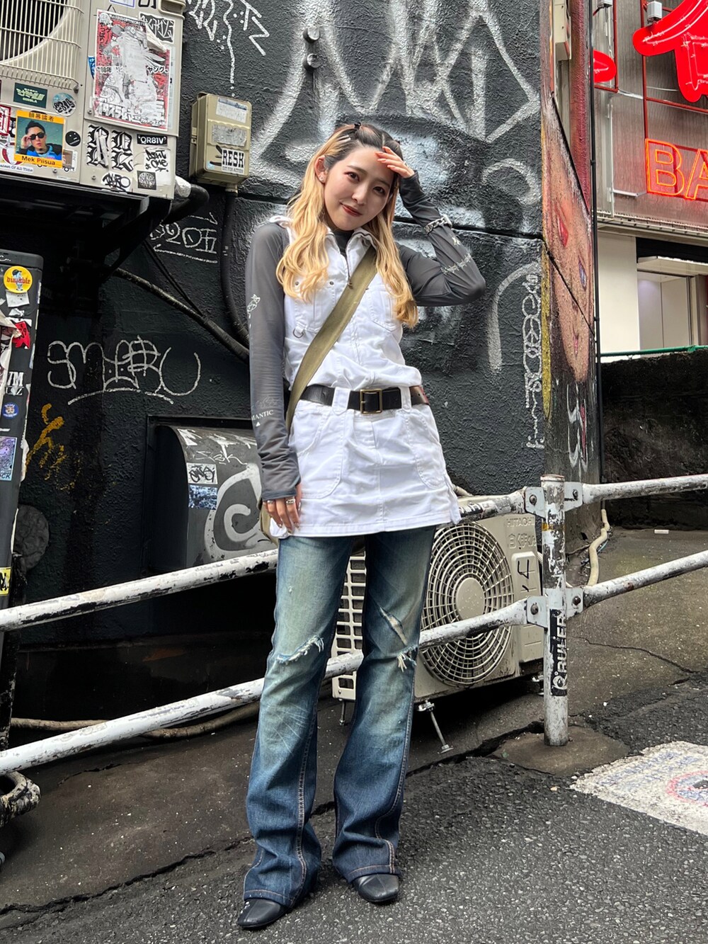 グレー系のTシャツ/カットソー、ホワイト系のジャンパースカート、ブルー系のデニムパンツを着用したレディースの春コーディネートの3枚目の写真