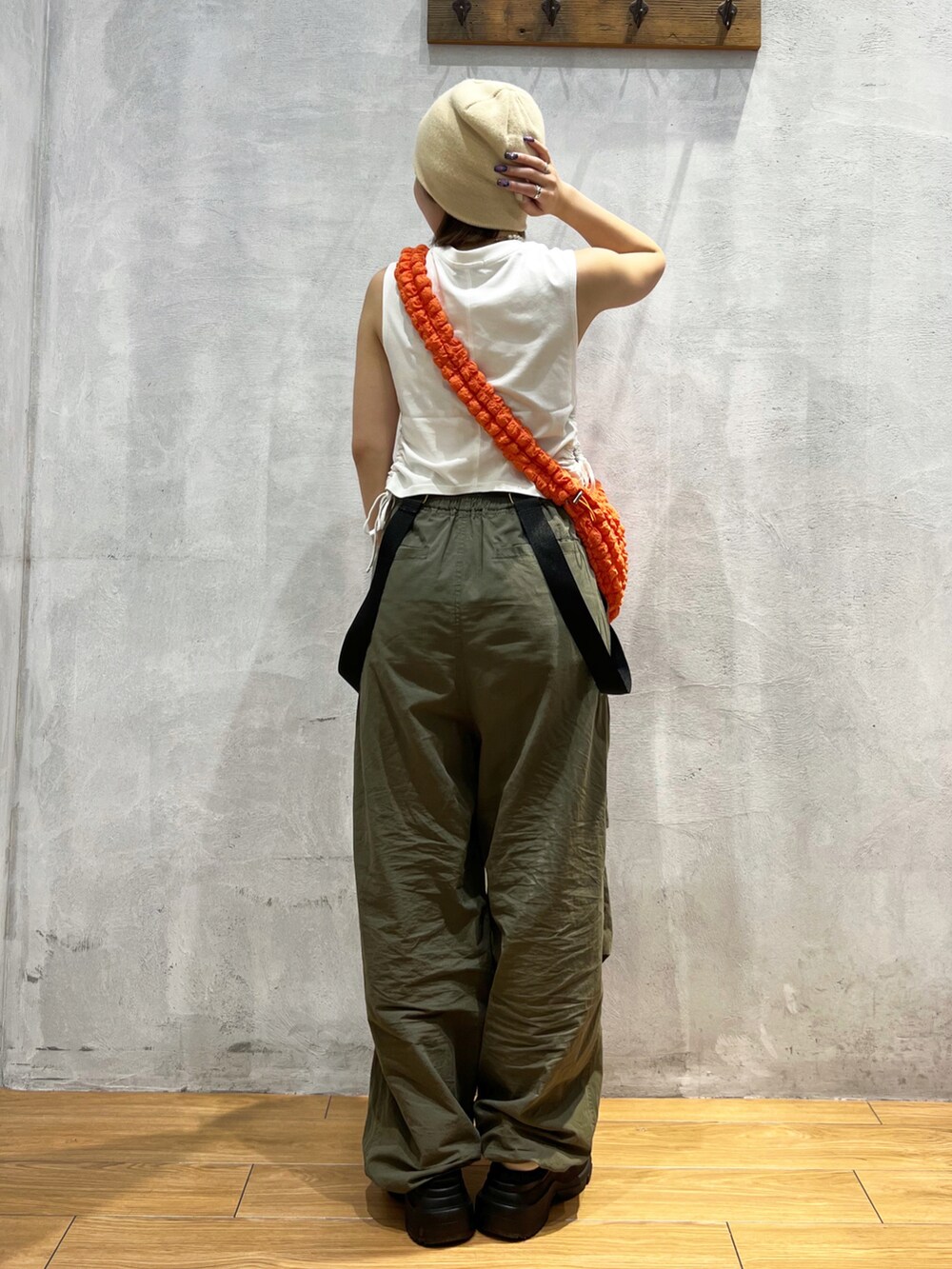 グリーン系のその他パンツ、ホワイト系のTシャツ/カットソー、オレンジ系のショルダーバッグを着用したレディースの夏コーディネートの4枚目の写真