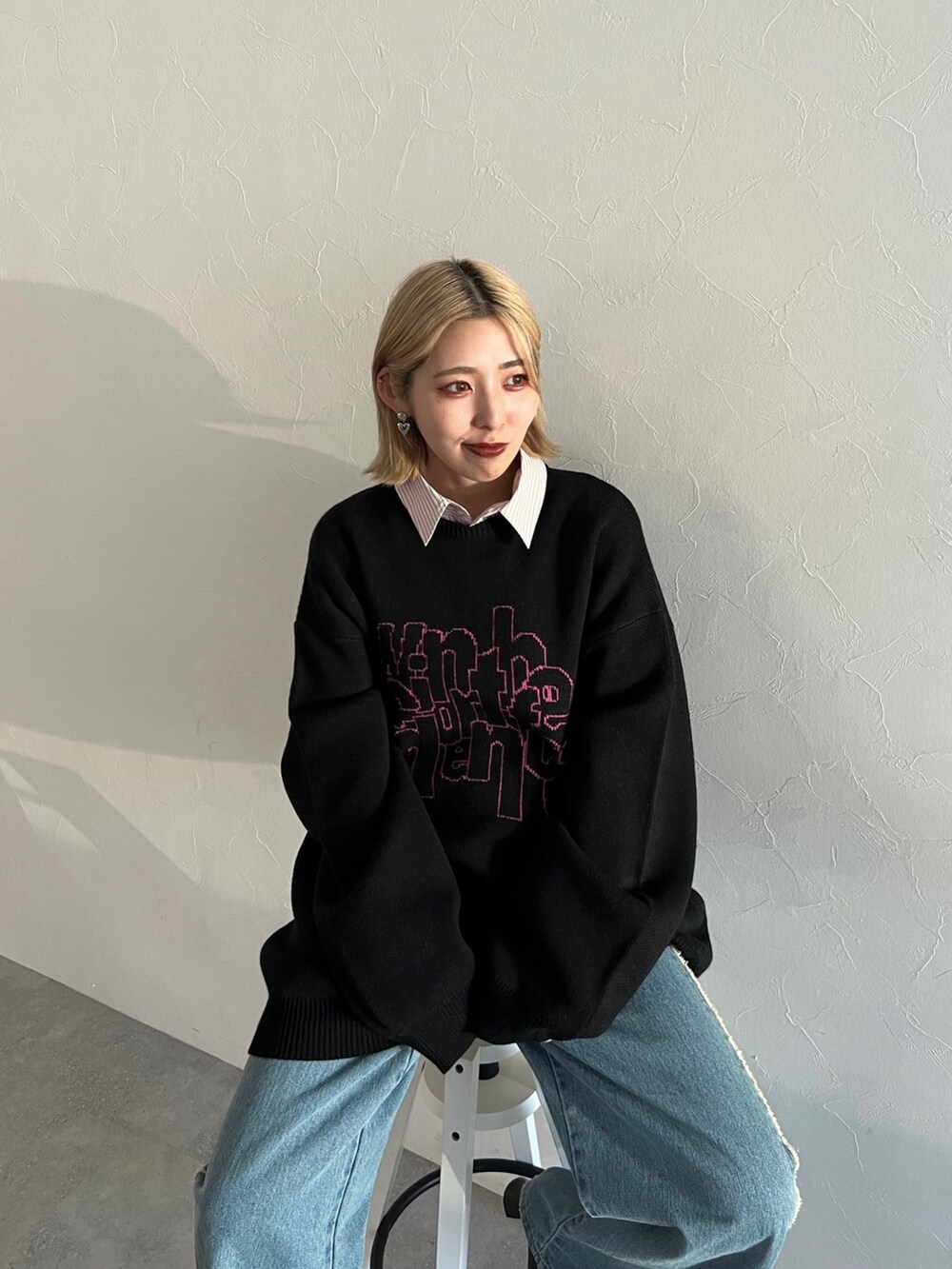 ブラック系のニット/セーター、ブルー系のデニムパンツ、ピンク系のシャツ/ブラウスを着用したレディースの秋コーディネートの2枚目の写真