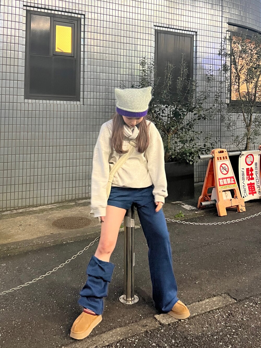 グレー系のスウェット、ブルー系のスウェットパンツ、ブラウン系のブーツを着用したレディースの春コーディネートの4枚目の写真