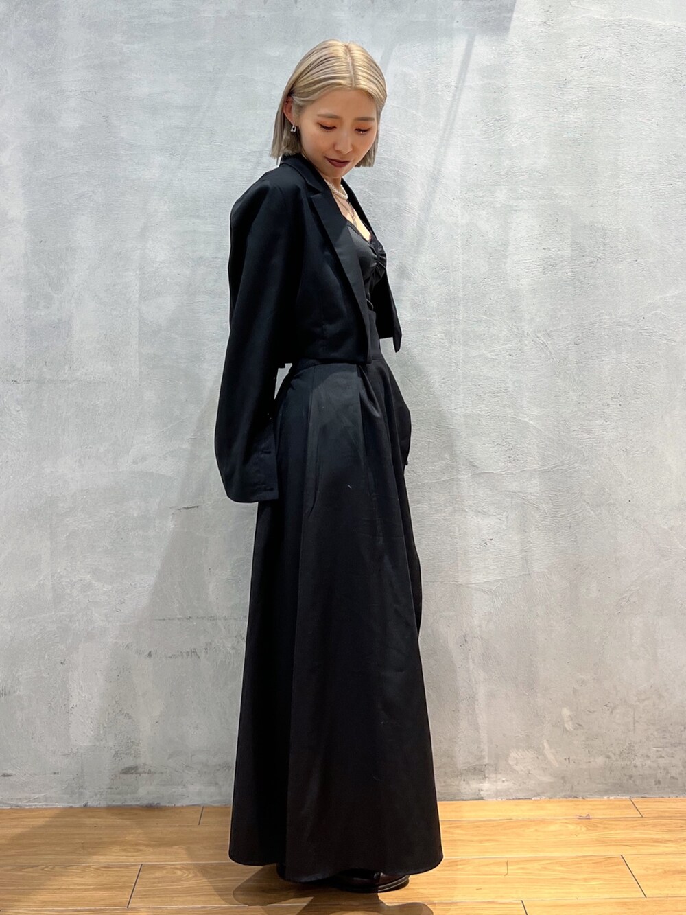 ブラック系のテーラードジャケット、ブラック系のスカートを着用したレディースの秋コーディネートの3枚目の写真