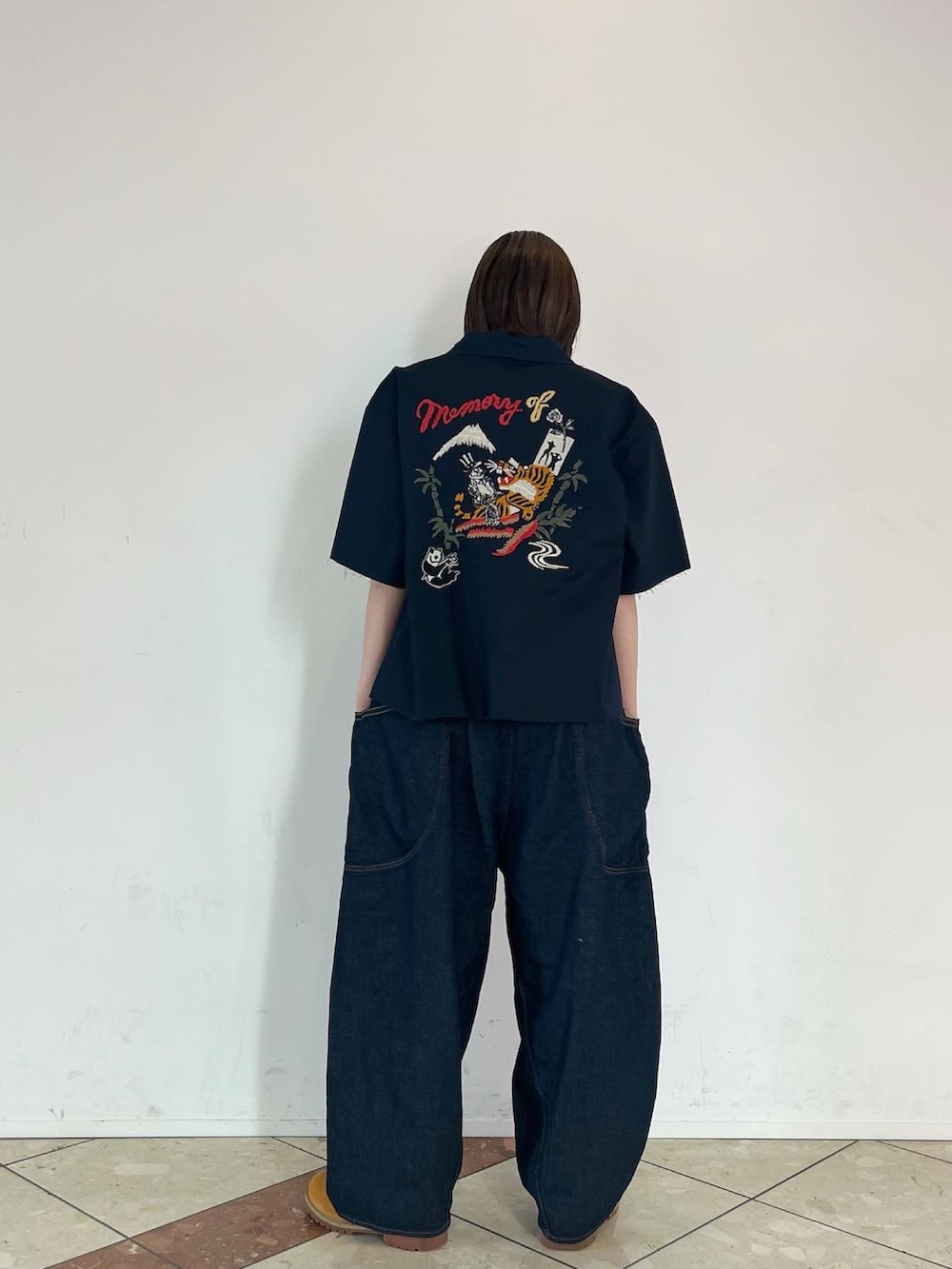 ブルー系のシャツ/ブラウス、ブルー系のデニムパンツ、ブラック系のブーツを着用したレディースの春コーディネートの2枚目の写真