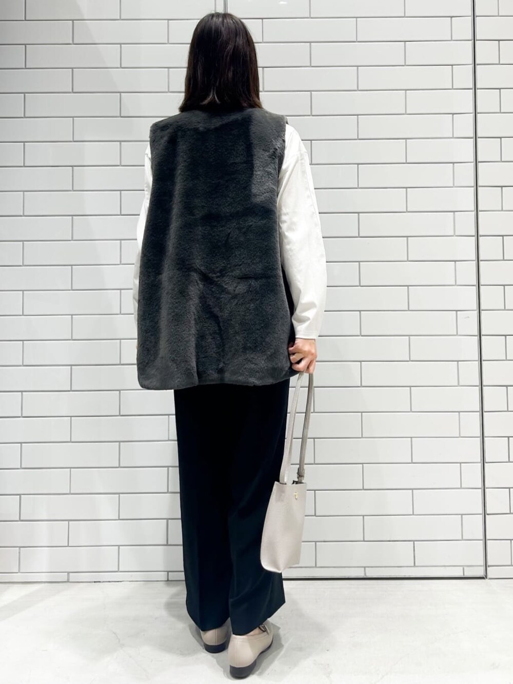 グレー系のパンプス、ブラック系のその他パンツ、グレー系のショルダーバッグを着用したレディースの秋コーディネートの3枚目の写真