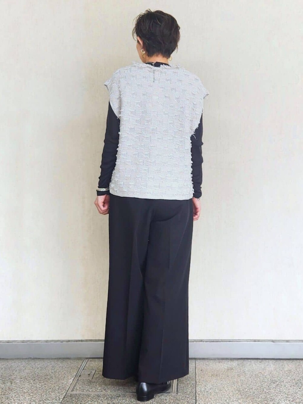 グレー系のニット/セーター、ブラック系のTシャツ/カットソー、ブラック系のその他パンツを着用したレディースの秋コーディネートの4枚目の写真