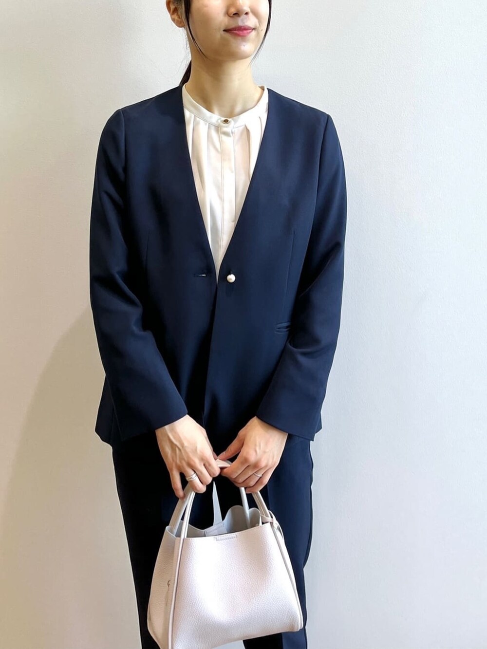 ブルー系のノーカラージャケット、ブルー系のその他パンツ、グレー系のショルダーバッグを着用したレディースの秋コーディネートの4枚目の写真