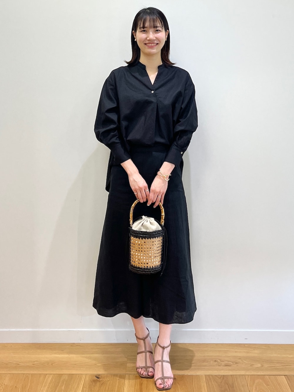 ブラウン系のサンダル、ブラック系のシャツ/ブラウス、ブラック系のトートバッグを着用したレディースの春コーディネートの2枚目の写真