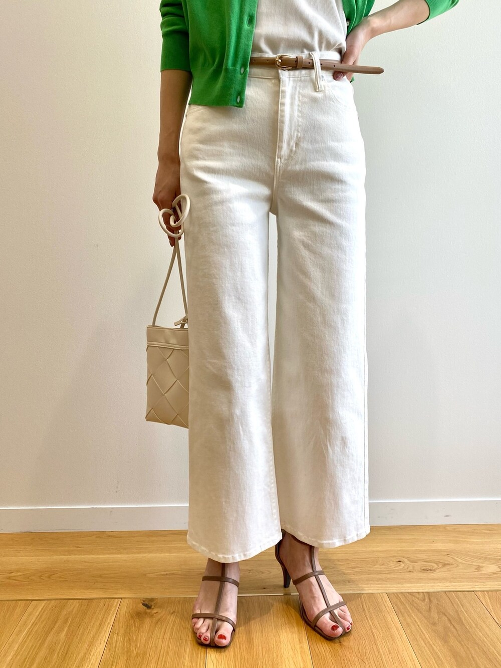 ブラウン系のサンダル、ホワイト系のショルダーバッグ、ホワイト系のデニムパンツを着用したレディースの春コーディネートの6枚目の写真