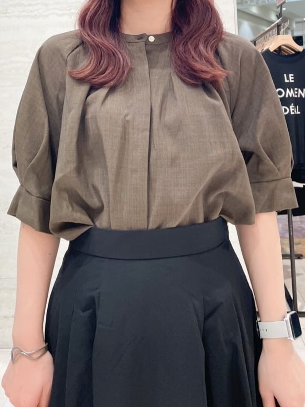 ブラウン系のシャツ/ブラウス、ブラック系のスカート、ホワイト系のパンプスを着用したレディースの秋コーディネートの2枚目の写真