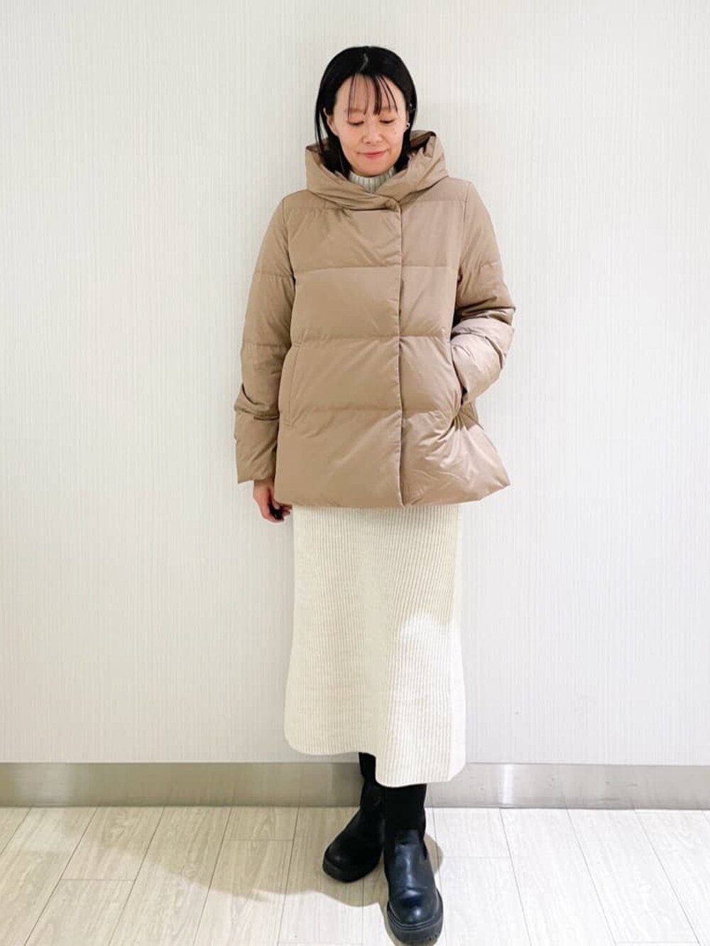 ホワイト系のスカート、ホワイト系のニット/セーター、イエロー系のダウンジャケット/コートを着用したレディースの秋コーディネートの4枚目の写真