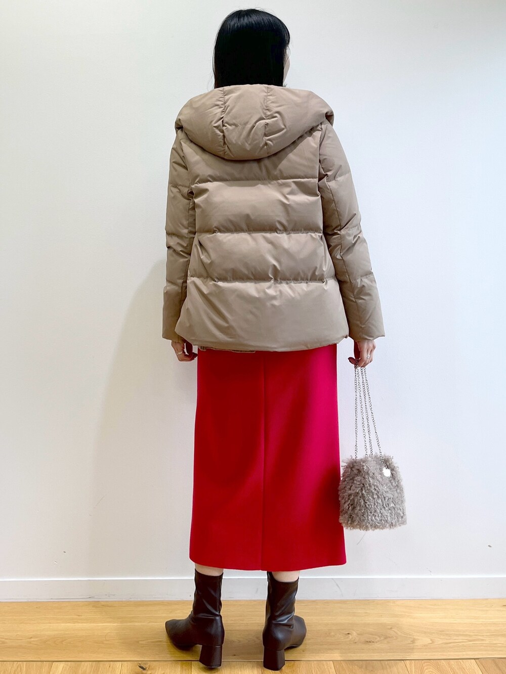 イエロー系のダウンジャケット/コート、ベージュ系のニット/セーター、レッド系のスカートを着用したレディースの秋コーディネートの4枚目の写真