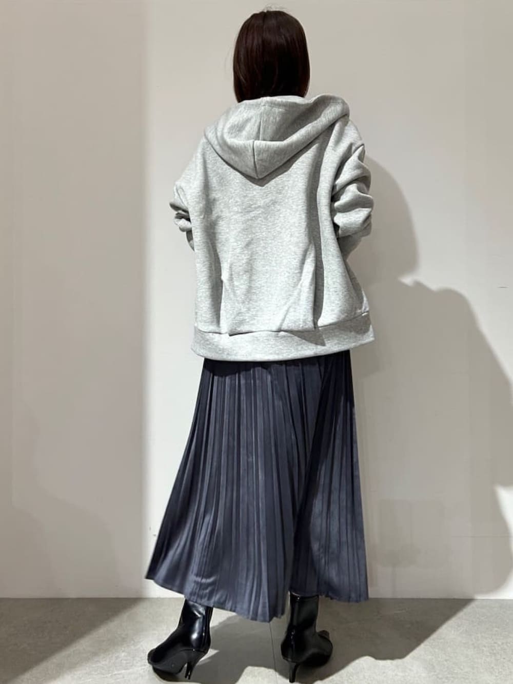 グレー系のスカート、ホワイト系のTシャツ/カットソー、グレー系のパーカーを着用したレディースの秋コーディネートの3枚目の写真