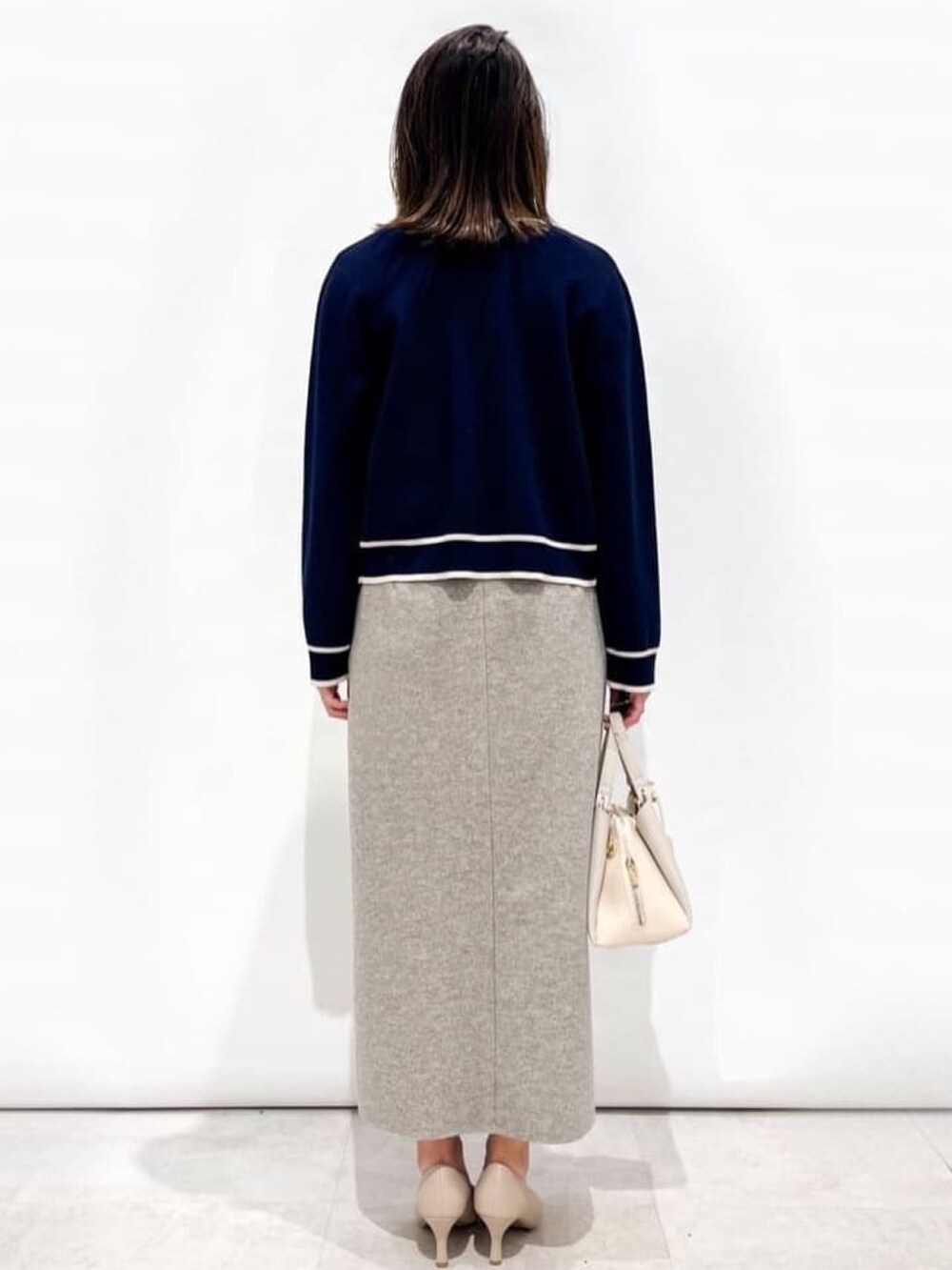 ブルー系のカーディガン/ボレロ、ブルー系のニット/セーター、グレー系のスカートを着用したレディースの冬コーディネートの4枚目の写真
