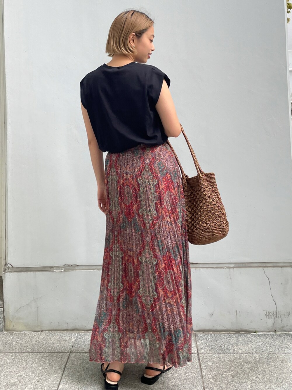 ブラック系のTシャツ/カットソー、オレンジ系のスカート、その他のトートバッグを着用したレディースの春コーディネートの2枚目の写真