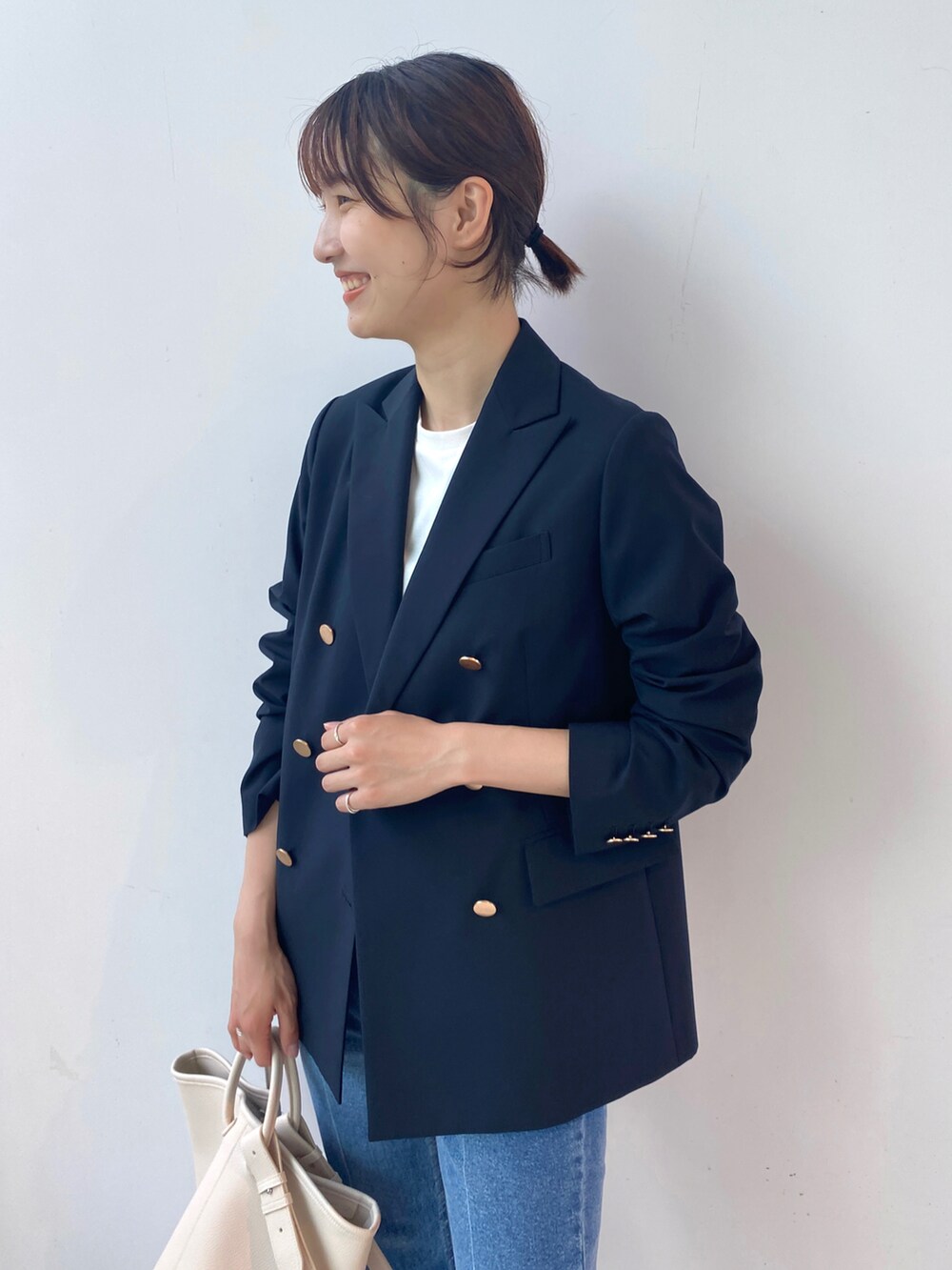 ブルー系のテーラードジャケット、ホワイト系のTシャツ/カットソー、ホワイト系のトートバッグを着用したレディースの夏コーディネートの3枚目の写真