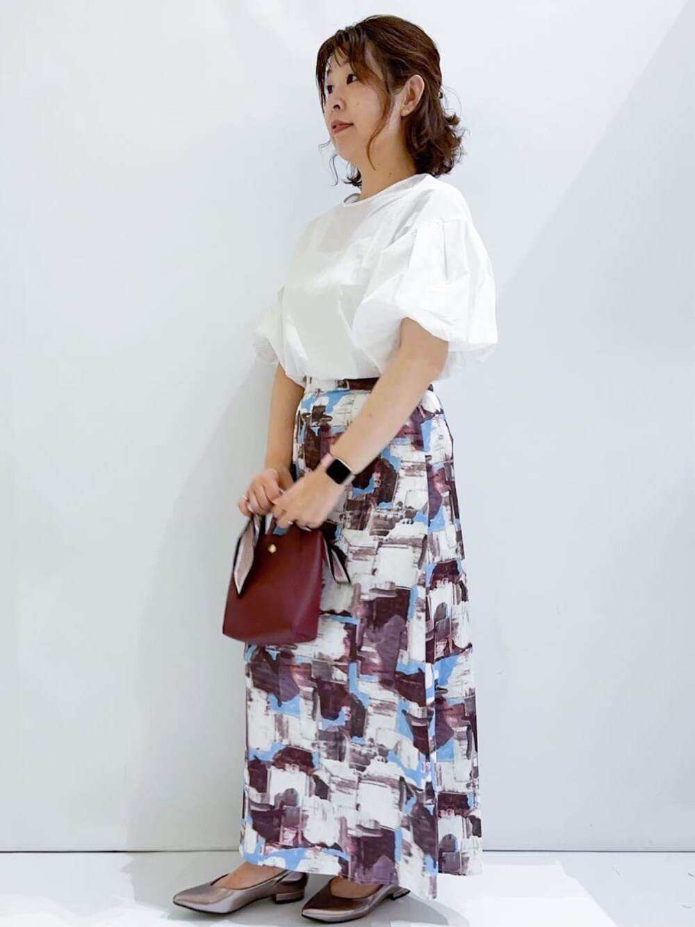 ホワイト系のシャツ/ブラウス、レッド系のスカート、レッド系のショルダーバッグを着用したレディースの夏コーディネートの2枚目の写真