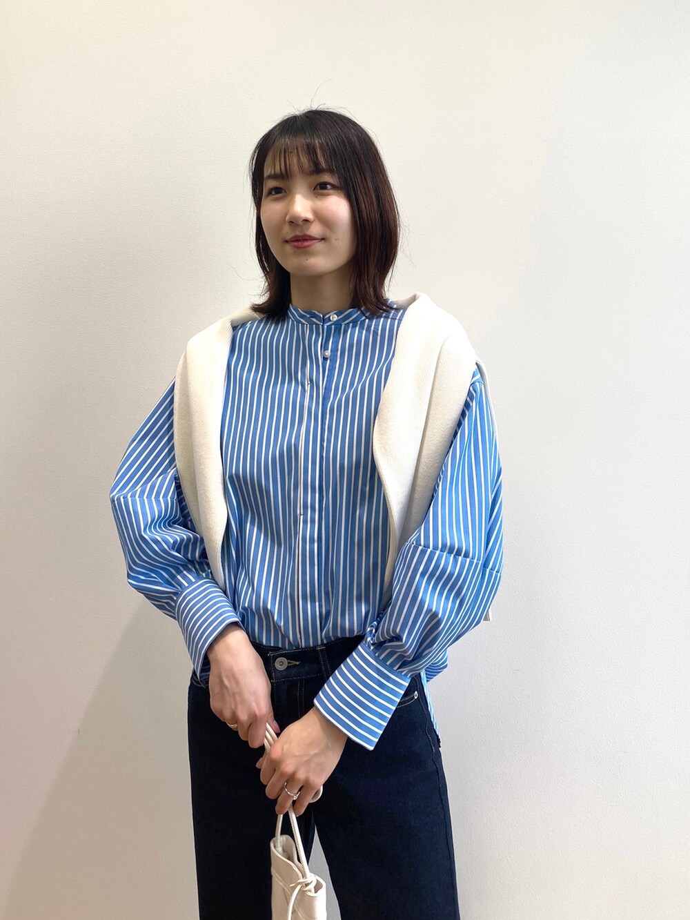 ブラウン系のサンダル、ブルー系のシャツ/ブラウス、ホワイト系のニット/セーターを着用したレディースの春コーディネートの3枚目の写真