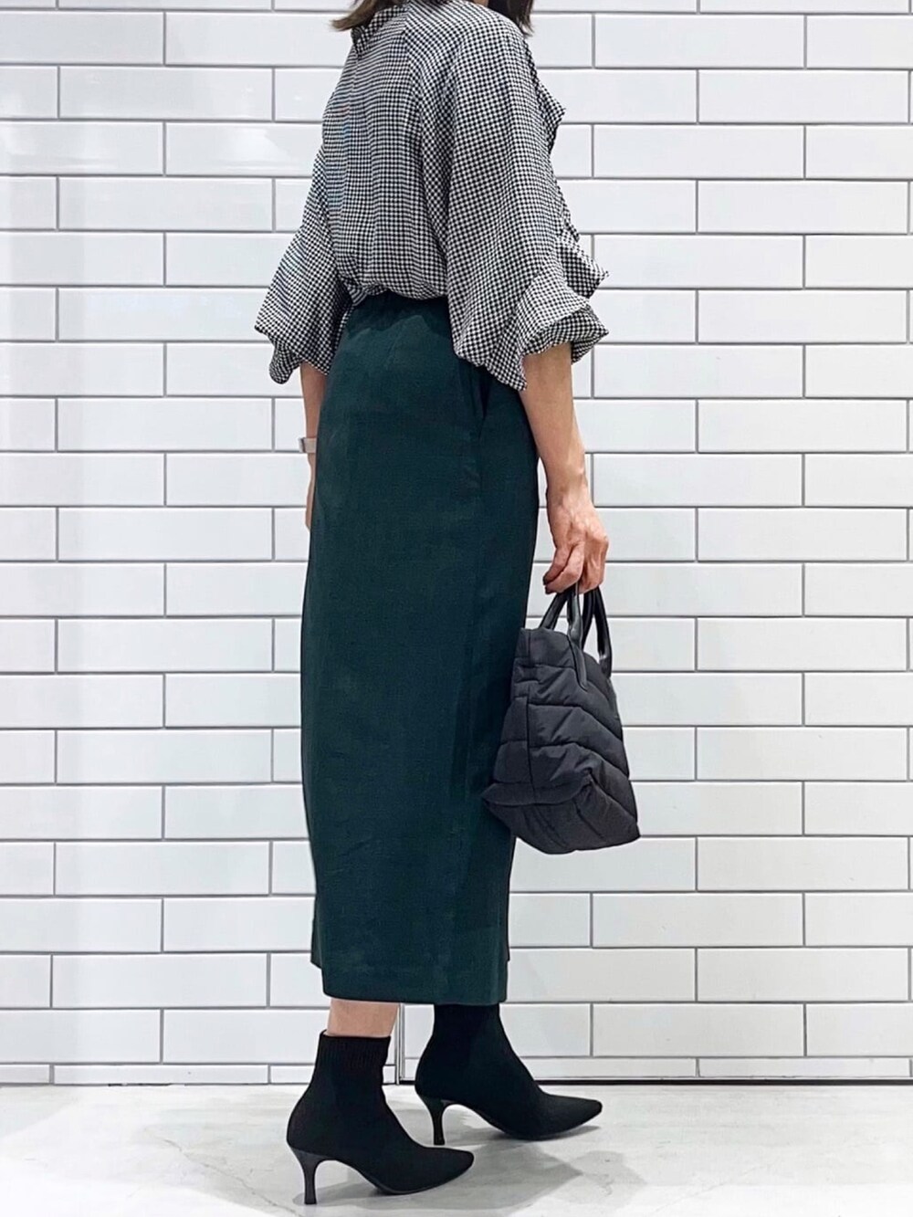 ブラック系のブーツ、ブラック系のシャツ/ブラウス、グリーン系のスカートを着用したレディースの秋コーディネートの3枚目の写真