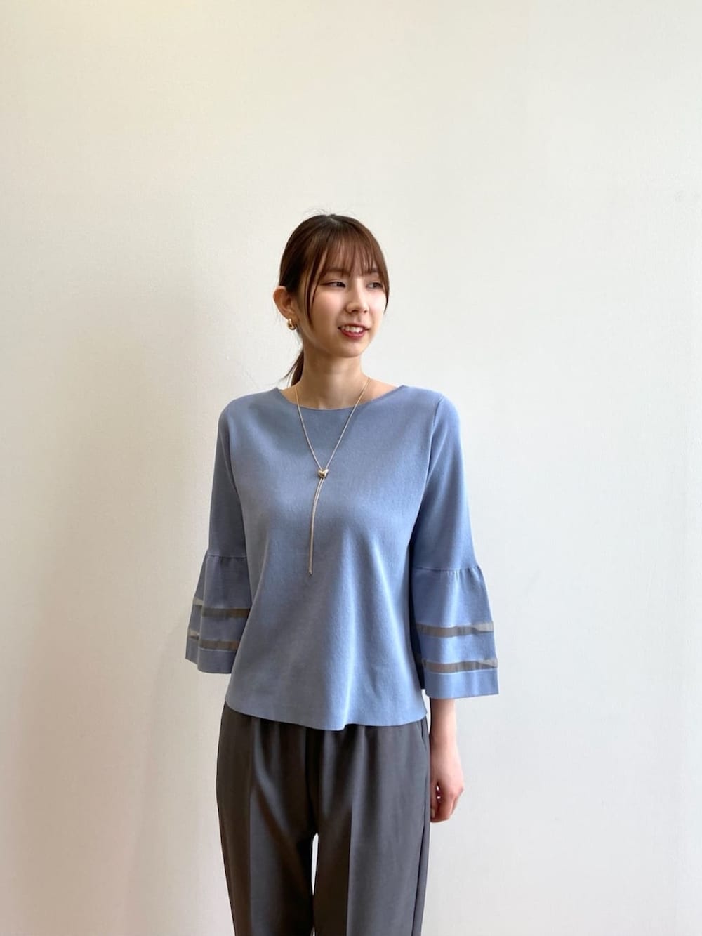 グレー系のその他パンツ、ベージュ系のパンプス、ブルー系のニット/セーターを着用したレディースの秋コーディネートの5枚目の写真