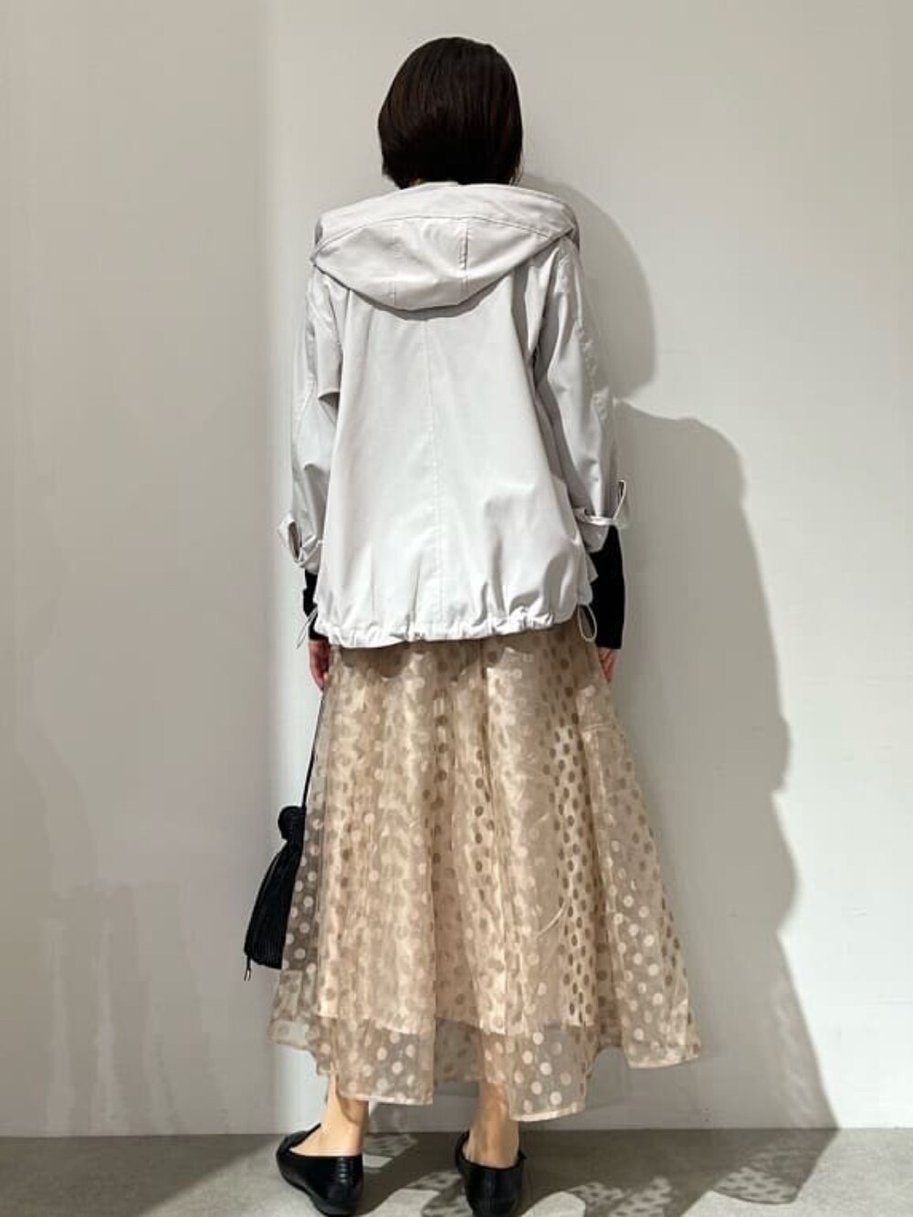 ベージュ系のブルゾン、ブラック系のニット/セーター、ベージュ系のスカートを着用したレディースの春コーディネートの3枚目の写真