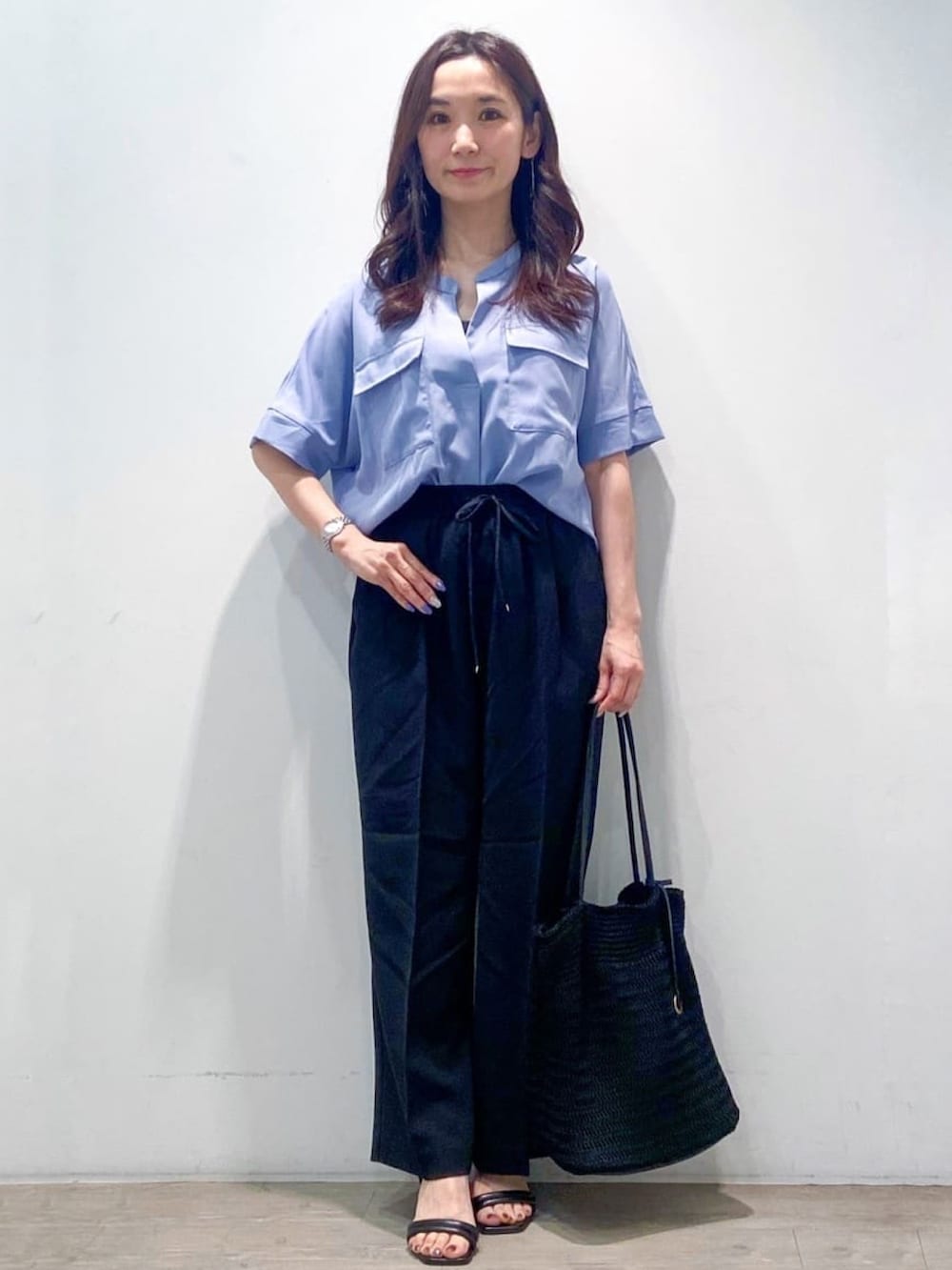 ブルー系のシャツ/ブラウス、ブラック系のその他パンツ、ブラック系のトートバッグを着用したレディースの春コーディネートの3枚目の写真