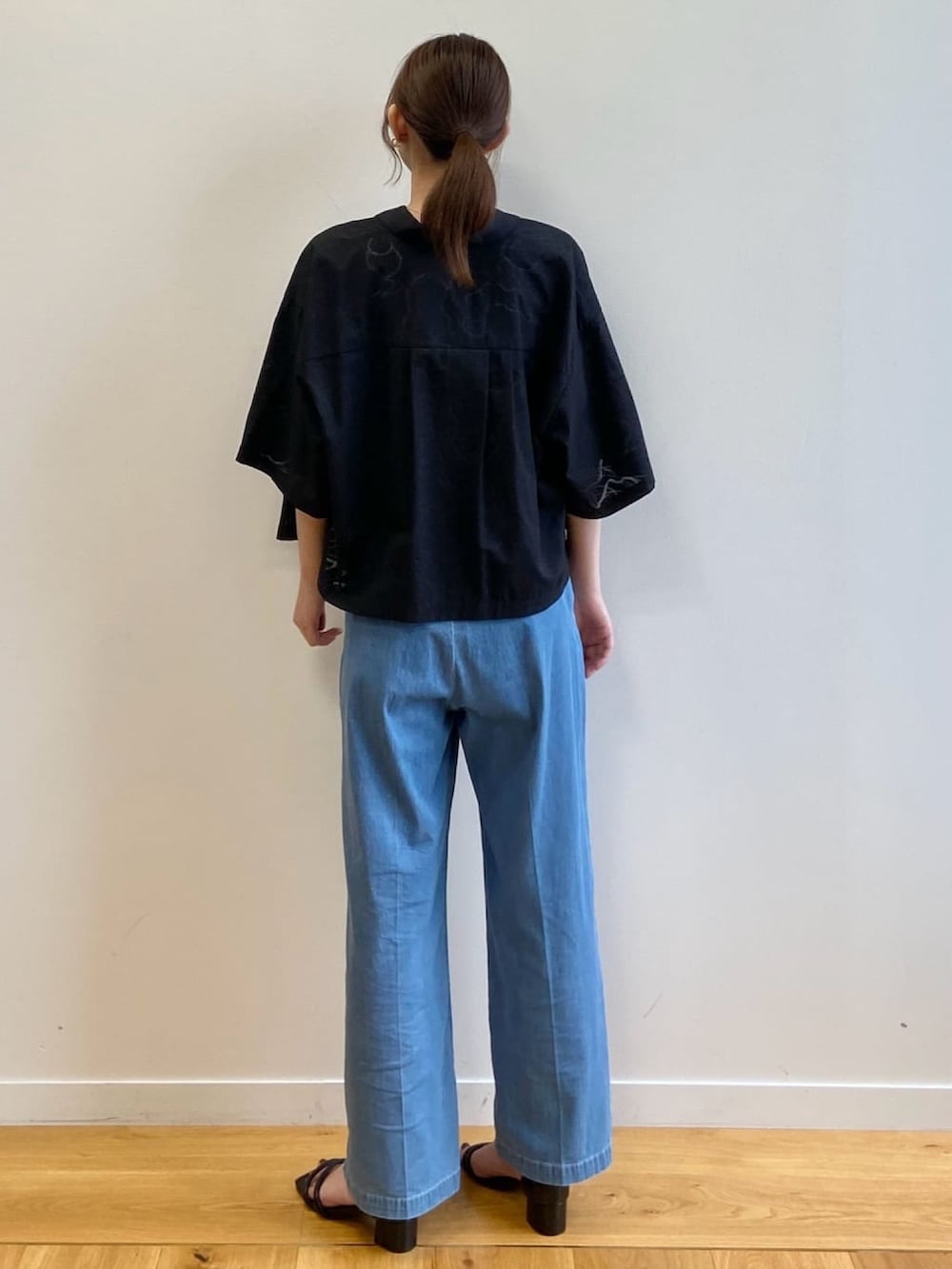 ブルー系のデニムパンツ、ブラック系のサンダル、ブラック系のシャツ/ブラウスを着用したレディースの夏コーディネートの4枚目の写真