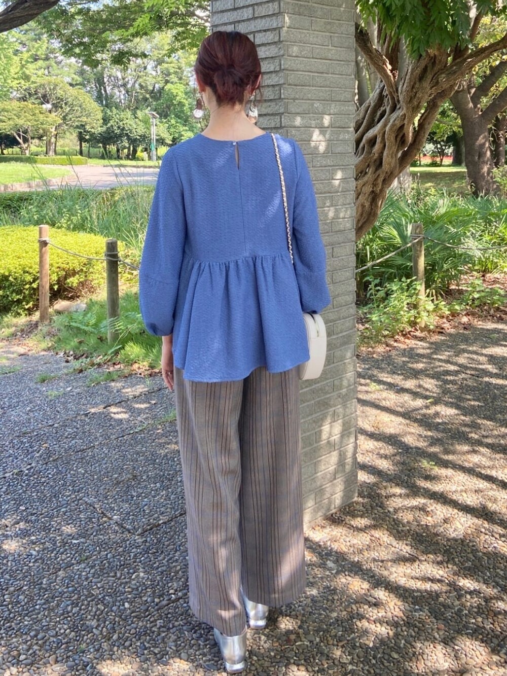 ブルー系のシャツ/ブラウス、シルバー系のパンプス、ブラウン系のその他パンツを着用したレディースの秋コーディネートの4枚目の写真