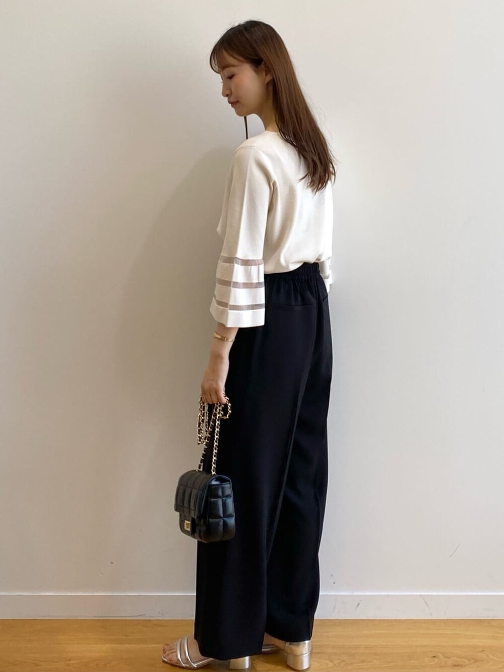 ホワイト系のニット/セーター、ブラック系のその他パンツ、ブラック系のショルダーバッグを着用したレディースの春コーディネートの5枚目の写真