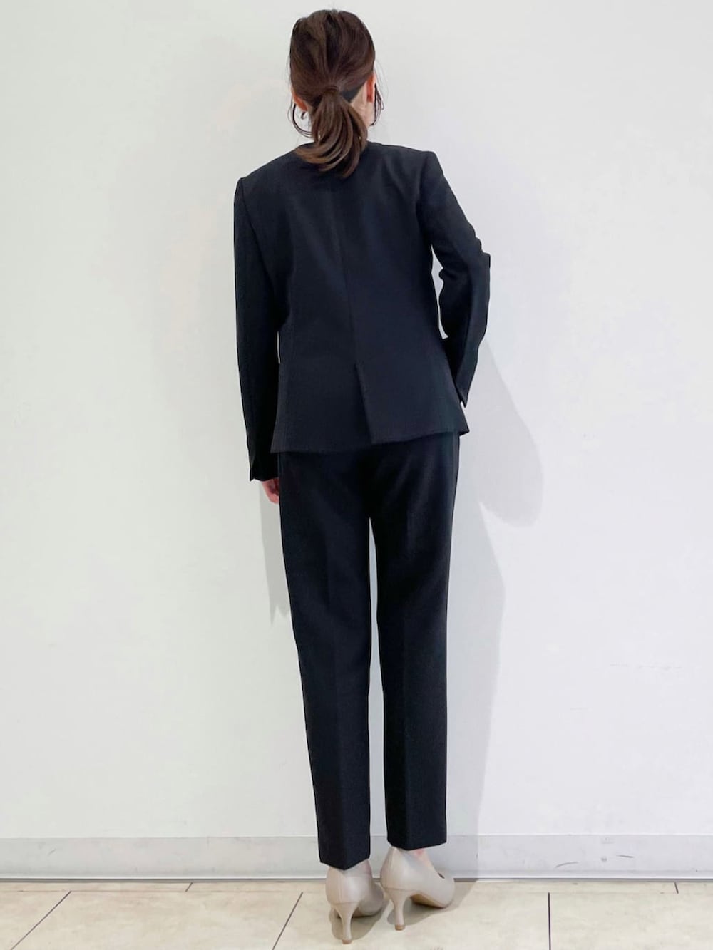 ブラック系のノーカラージャケット、ベージュ系のシャツ/ブラウス、グレー系のパンプスを着用したレディースの冬コーディネートの2枚目の写真