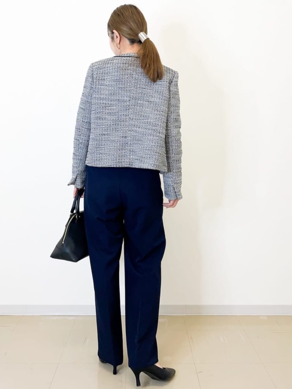 ブラック系のノーカラージャケット、ブルー系のその他パンツ、ホワイト系のシャツ/ブラウスを着用したレディースの冬コーディネートの2枚目の写真