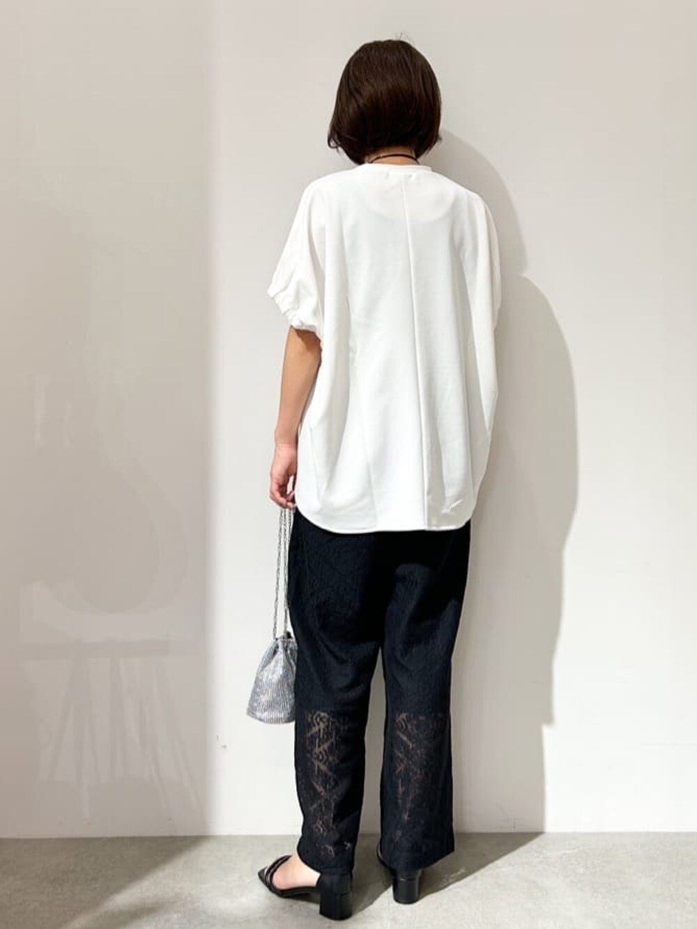 ホワイト系のTシャツ/カットソー、ブラック系のその他パンツ、ブラック系のサンダルを着用したレディースの春コーディネートの3枚目の写真