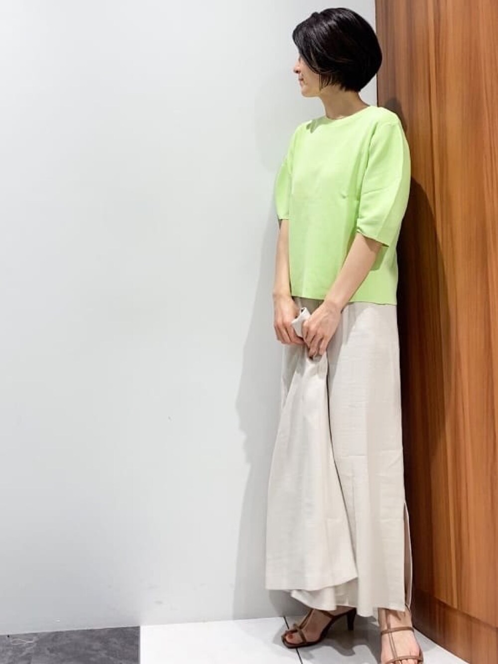 ベージュ系のテーラードジャケット、ベージュ系のスカート、ブラウン系のサンダルを着用したレディースの春コーディネートの5枚目の写真