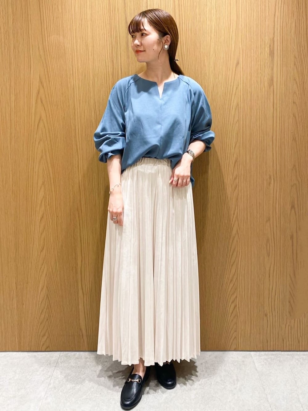 ホワイト系のスカート、グレー系のブルゾン、ブルー系のTシャツ/カットソーを着用したレディースの秋コーディネートの4枚目の写真