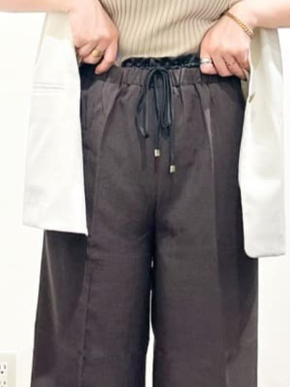 ベージュ系のノーカラージャケット、ベージュ系のニット/セーター、ブラック系のショルダーバッグを着用したレディースの夏コーディネートの7枚目の写真