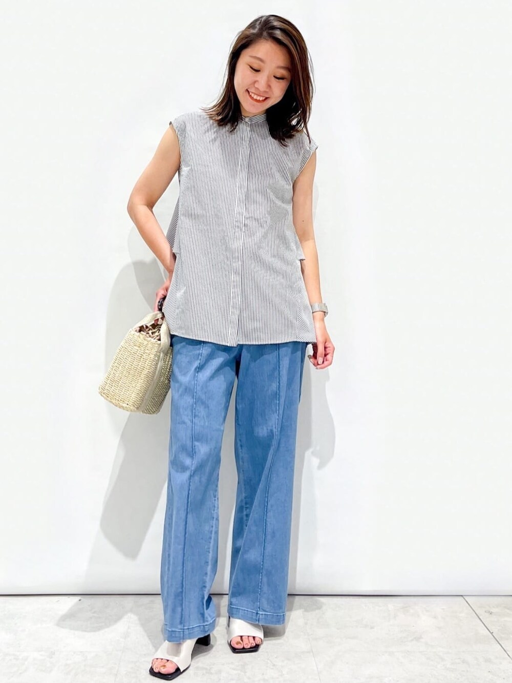 ホワイト系のシャツ/ブラウス、ホワイト系のサンダル、ゴールド系のショルダーバッグを着用したレディースの夏コーディネートの2枚目の写真