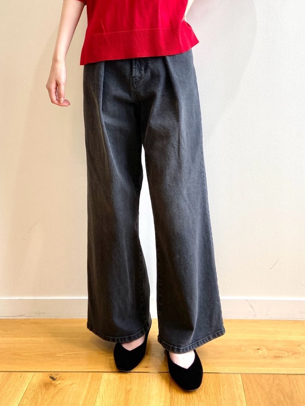 レッド系のニット/セーター、ブラック系のデニムパンツ、ブラック系のパンプスを着用したレディースの秋コーディネートの6枚目の写真